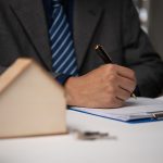 Businessman signing contract for buying a house or real estate agent. Investment and bank loan